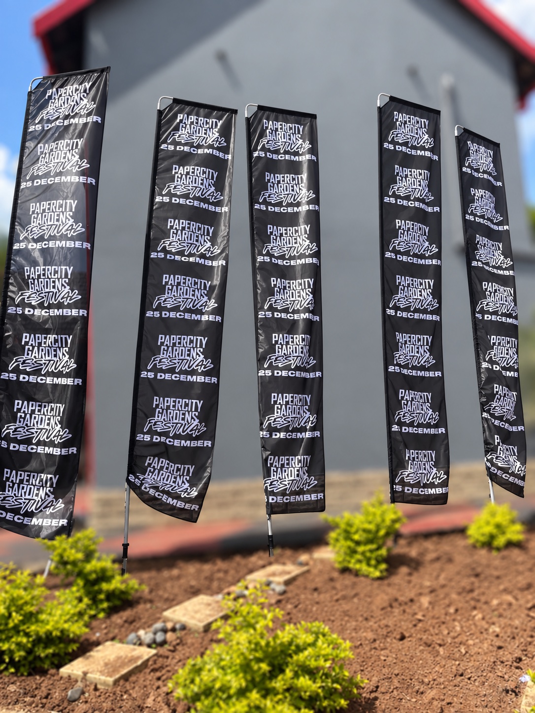 Branded festival flags installed along a garden venue approach
