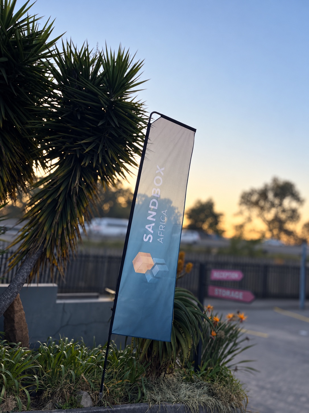 Sandbox Africa branded outdoor flag beside an event venue